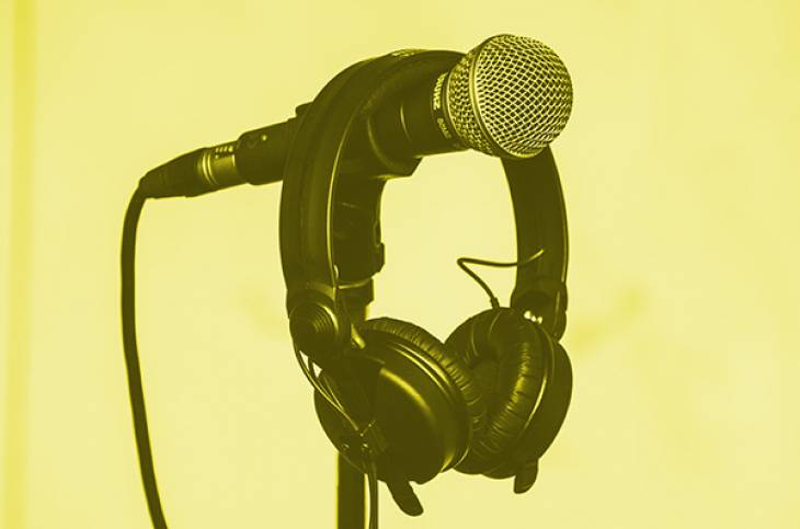 Imagem de um microfone com fones pendurados